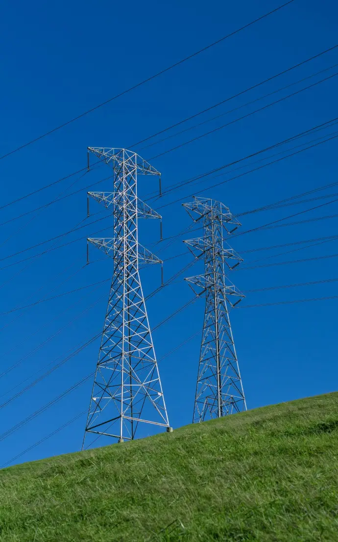 a couple of power lines sitting on top of a lush green hillside
